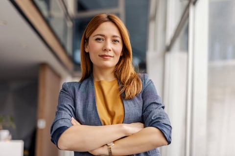 Portrait of female leader standing at corporate firm with arms crossed
