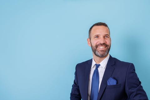 Smiling businessman in a suit and tie looking away, confident and successful