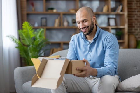 Cheerful customer receiving and unboxing a delivery package from an online store
